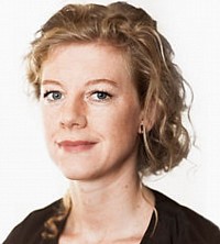 Una mujer de cabello rubio con una camisa negra, encarnando la esencia de una clienta moderna.